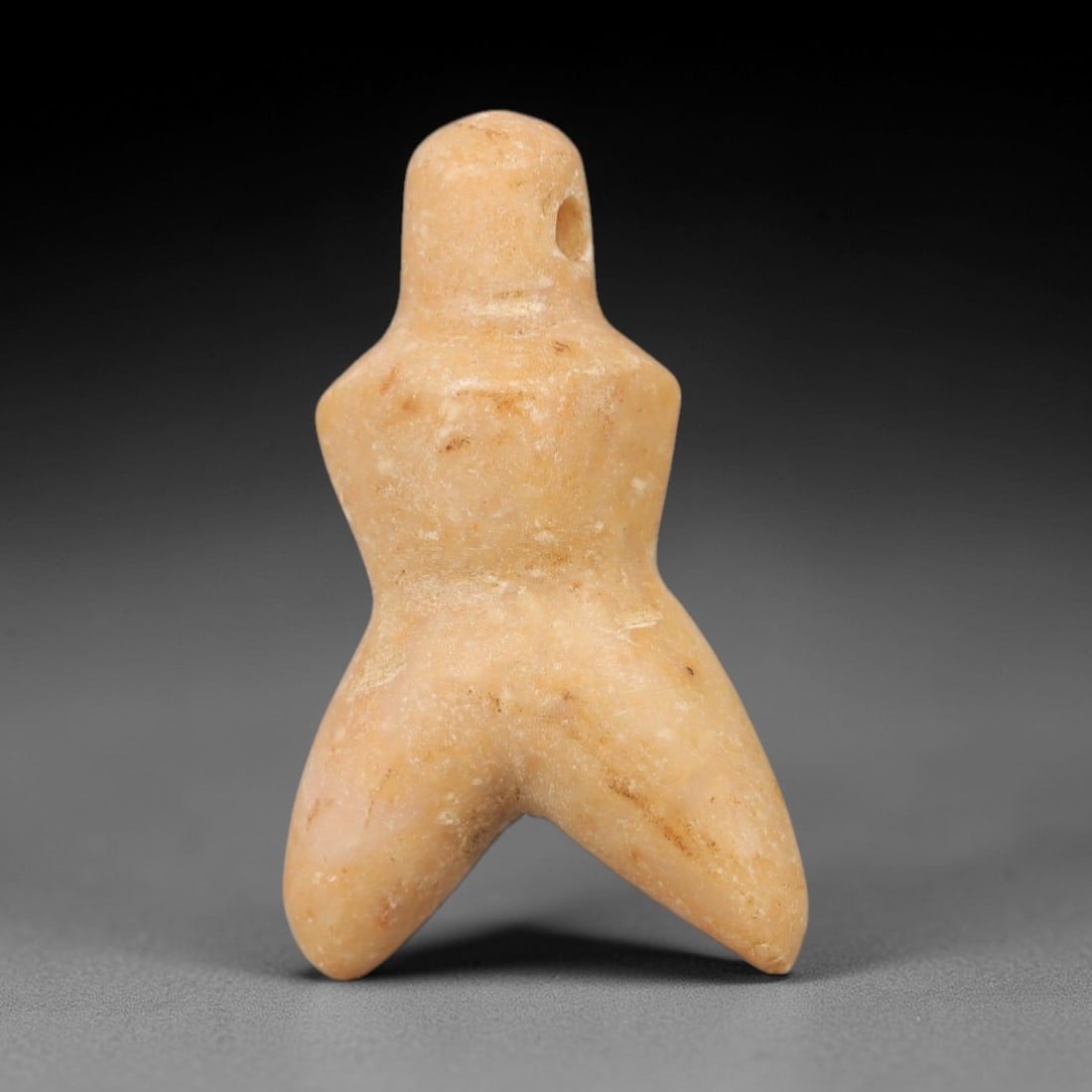 Ancient Stone Fertility Idol - Near Eastern Ritual Figurine, 22AG: This amulet is carved from a single piece of pale tan stone, exhibiting a fine-grained texture with subtle ochre patina and faint mineral veining across its surface. The form is a stylized anthropomor