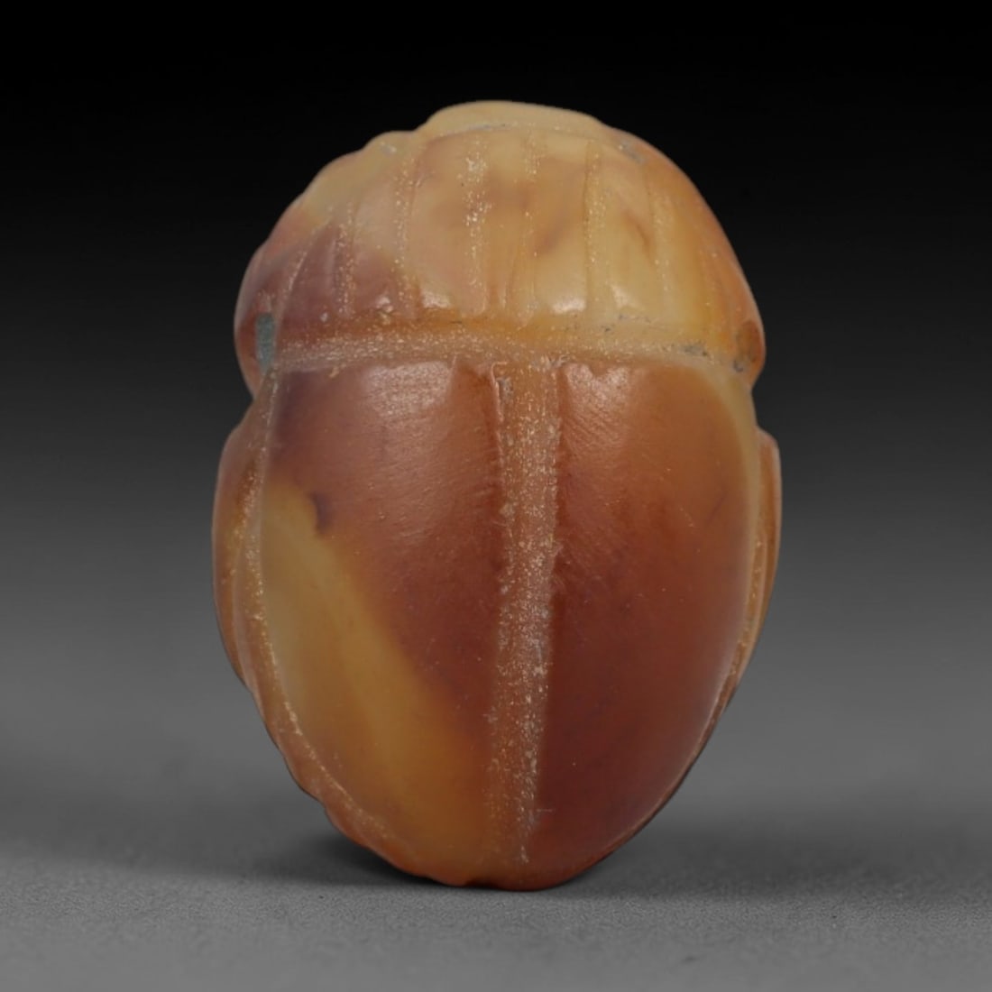 Ancient Banded Agate Scarab Amulet - Egyptian Figurine, 19AJ: Carved from warm banded agate with creamy yellow and deep amber-red natural gradients, this amulet is formed as a stylized scarab beetle with incised linear detailing to define segmented head plates,