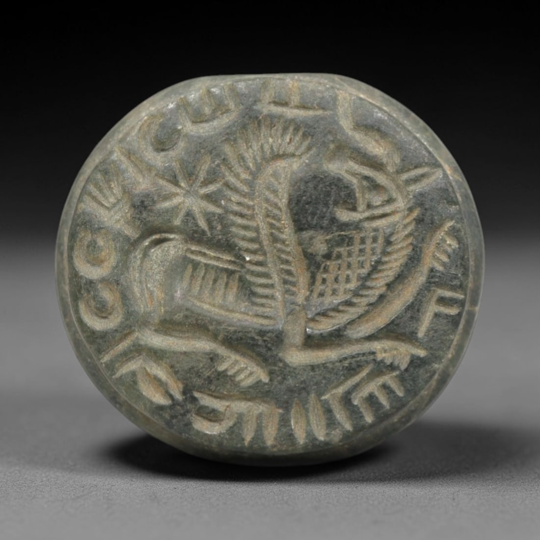 Ancient Stone Hemispherical Stamp Seal - Near Eastern Griffin & Script, 50ZP: Crafted from a fine-grained, greenish stone, this hemispherical stamp seal bears a deeply incised composition featuring a stylized griffin-like winged quadruped, rendered in linear relief with detaile