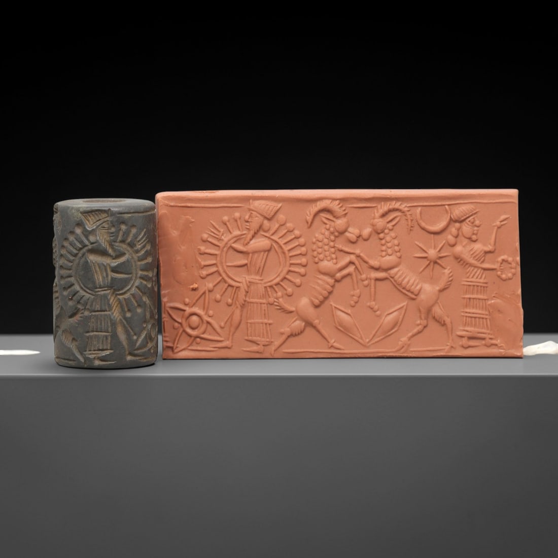 Ancient Steatite Cylinder Seal - Mesopotamian Royal Hunt & Sun Deity Scene, 46AL: Carved from dark, finely grained steatite, this ancient Mesopotamian cylinder seal depicts a dramatic royal ritual scene, executed with masterful glyptic craftsmanship characteristic of the Neo-Assyri