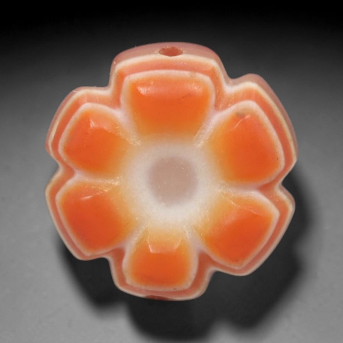Antique Agate Six-Petaled Flower Bead - Central Asian Carved Gemstone, 5ZW: Carved from banded agate with warm orange and creamy white natural banding, this bead features a symmetrical six-petaled floral form with faceted, raised orange petals and a hollow central cavity. A t