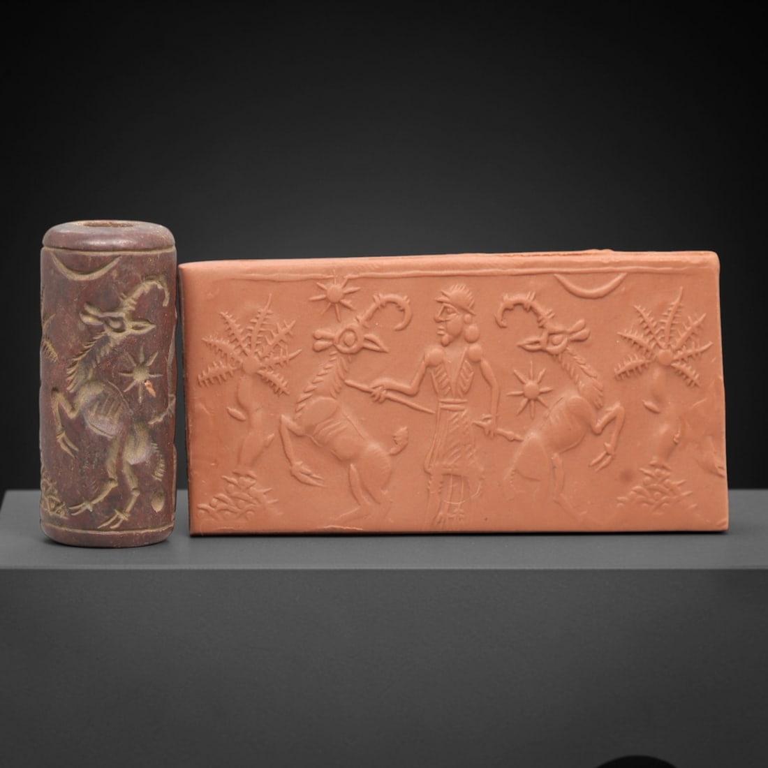 Ancient Steatite Cylinder Seal - Mesopotamian Ibex Hunt Scene, 48AL: Carved from rich, reddish-brown steatite, this ancient Mesopotamian cylinder seal depicts a dynamic hunting scene, executed with precise glyptic craftsmanship characteristic of the Late Bronze Age. Th