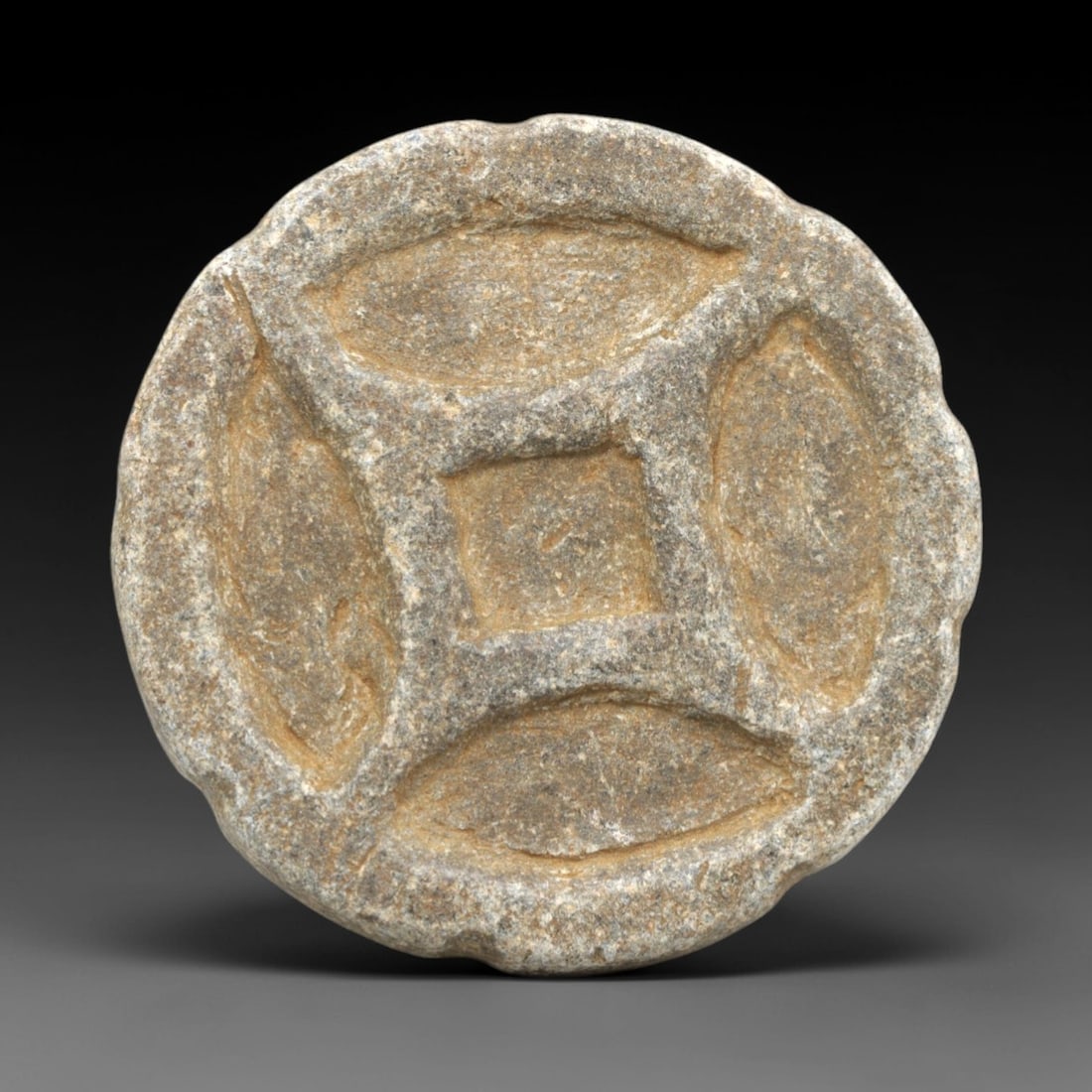 Ancient Schist Stamp Seal - Near Eastern Geometric Motif, 67ZP: This lobed circular stamp seal is carved from schist, featuring a central square recess surrounded by four symmetrical, oval-shaped recessed motifs forming a cross-like geometric design. Stylistically