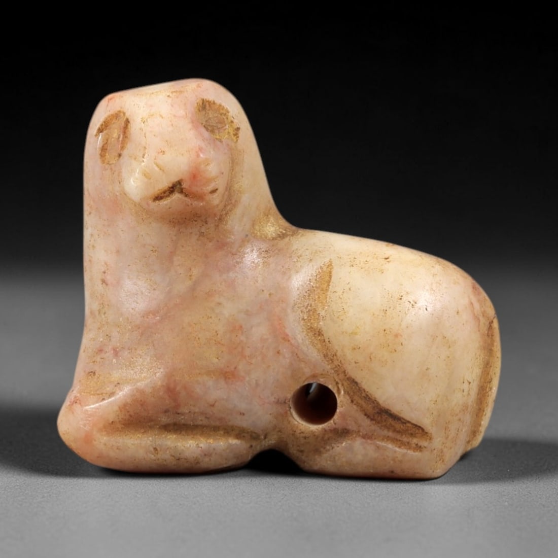 Ancient Pink Stone Feline - Near Eastern Amulet Figurine, 37AS: This amulet is carved from smooth pinkish stone, exhibiting a subtle, striated texture and warm earthy patina consistent with ancient Near Eastern burial contexts. The form depicts a recumbent feline,