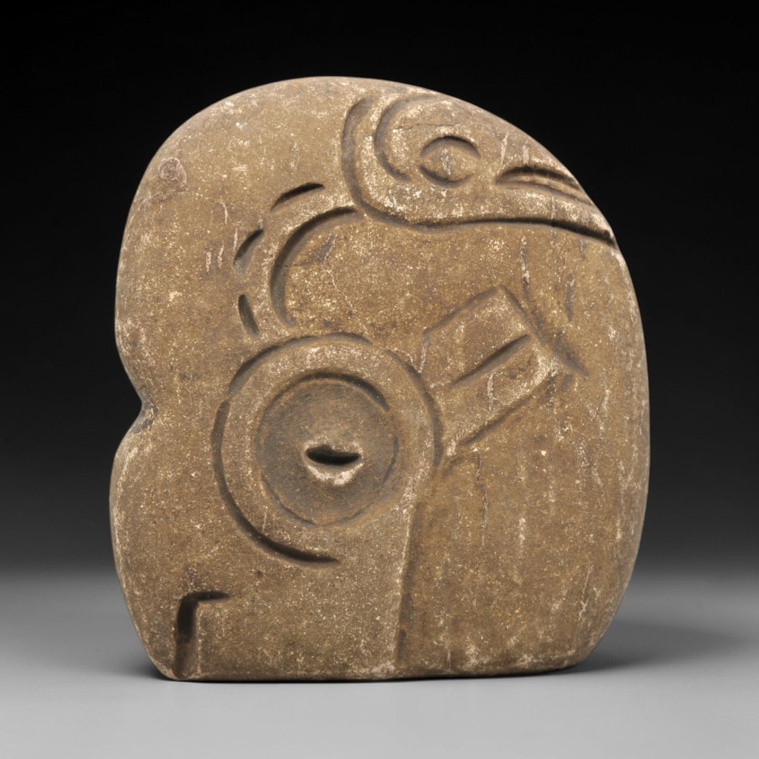 Ancient Stone Anthropomorphic Idol - Near Eastern Eye Figurine, 88ZV: This artifact is a carved stone anthropomorphic idol, crafted from a granular, earth-toned stone consistent with ancient Near Eastern lithic traditions. The relief carving features a prominent concent