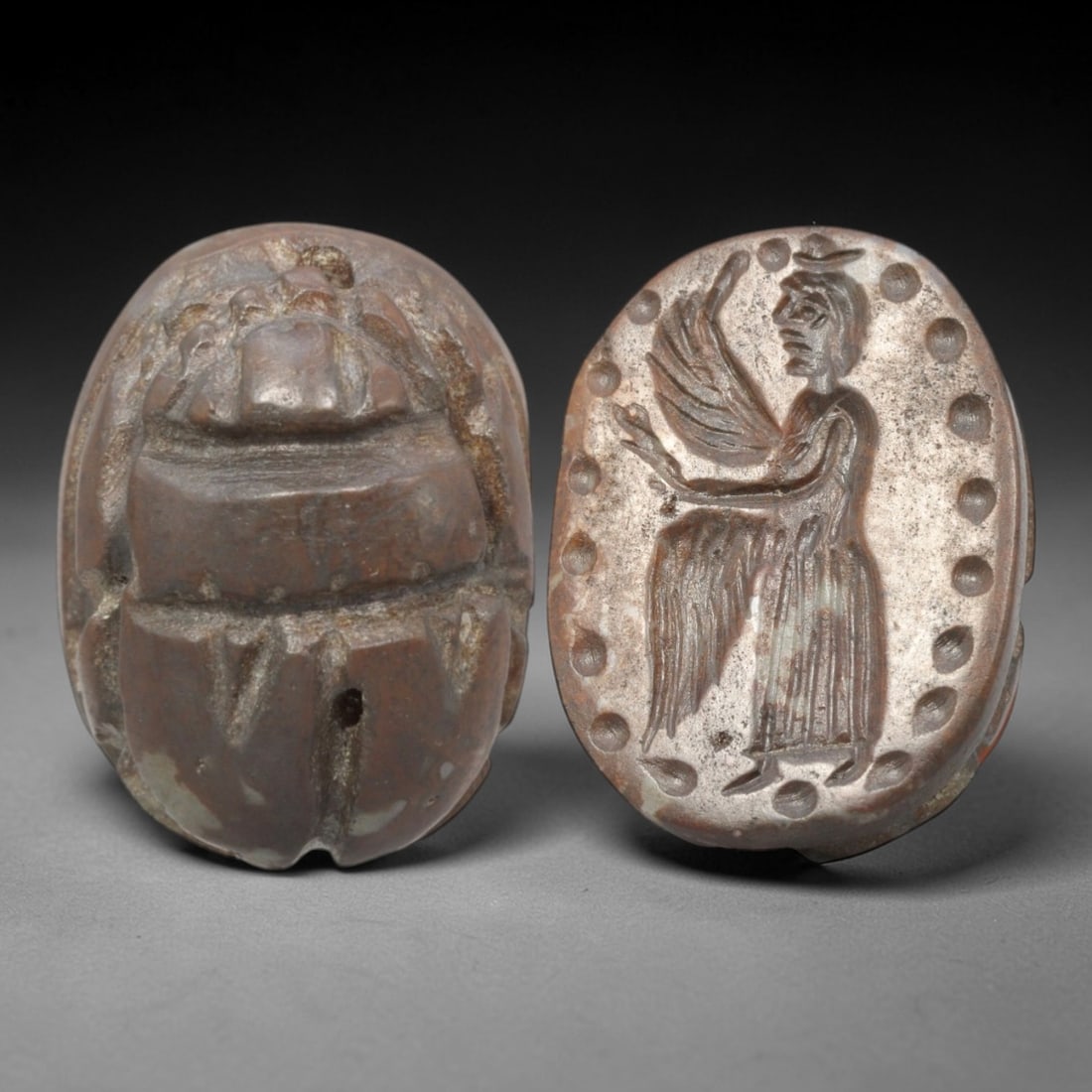 Ancient Hardstone Scarab - Near Eastern Winged Figural Seal, 64AS: This artifact is hand-carved from a warm brown hardstone, utilizing traditional ancient seal craftsmanship consistent with Near Eastern or Phoenician Iron Age traditions. The object takes the form of
