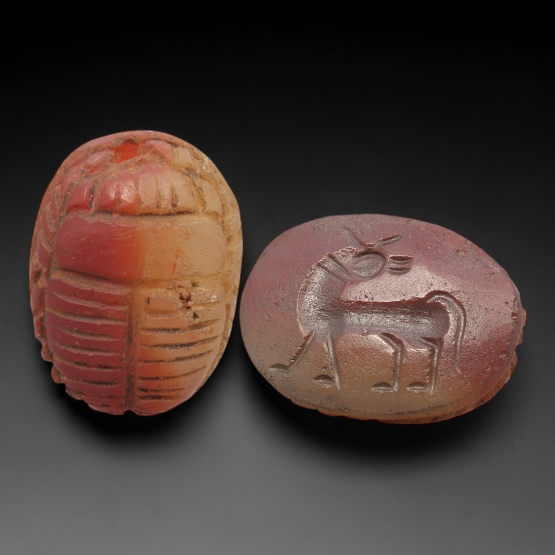 Ancient Carnelian Scarab - Near Eastern Ibex Zoomorphic Seal, 67AS: This artifact is hand-carved from rich red-orange carnelian, employing traditional ancient lapidary techniques consistent with Near Eastern Bronze Age seal craftsmanship. The object takes the form of