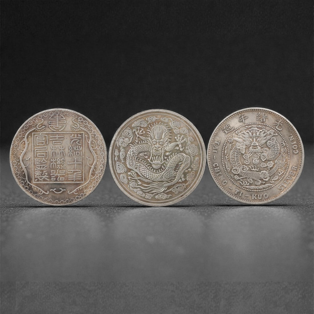 Three Chinese Commemorative Medallions Coins, 20th Century, 79FN: The group comprises three circular commemorative medallions, each with a diameter of 3.9 cm (1 1/2 in.). The first medallion features a square panel of inscriptions framed by scrollwork on the obverse