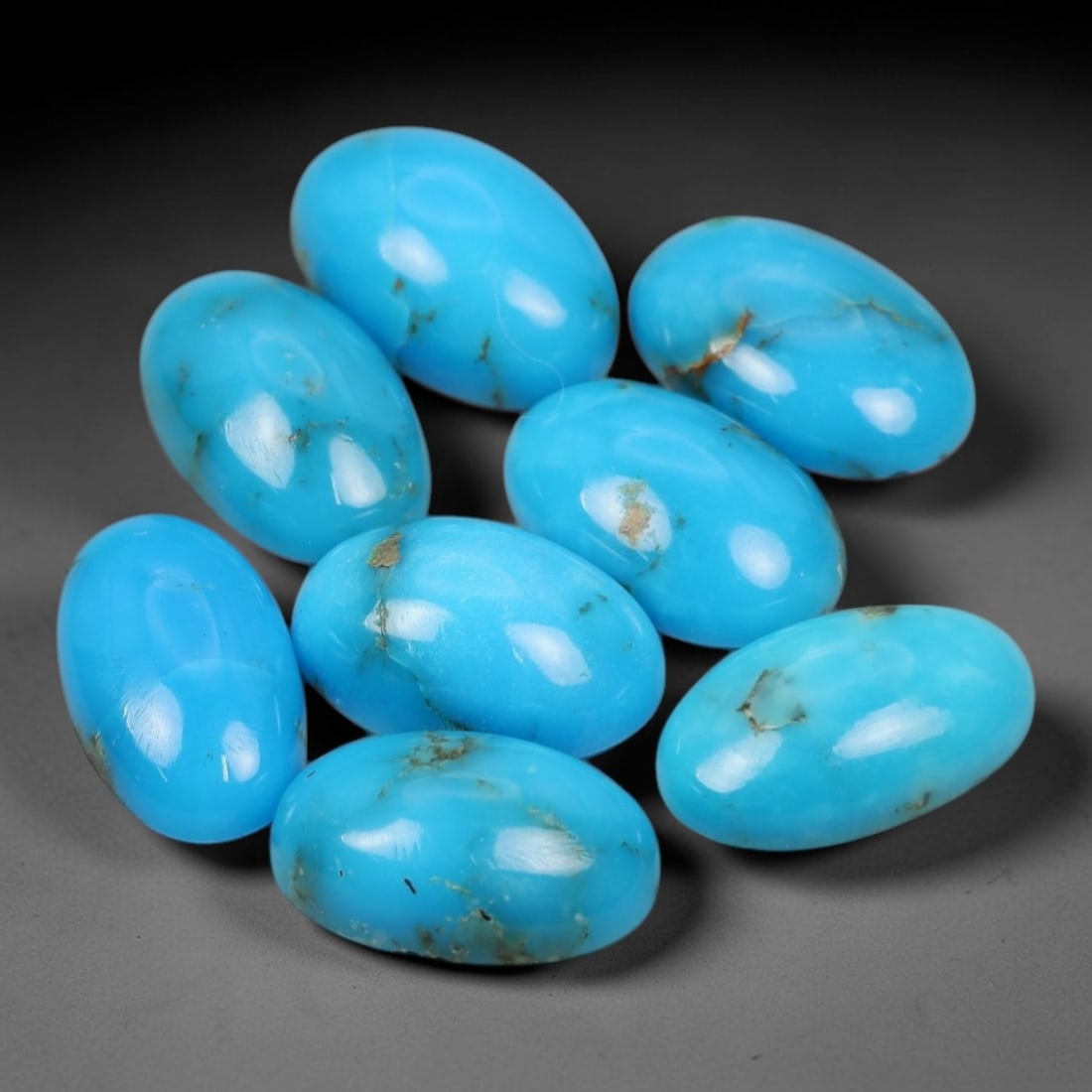 12.03 Carats Natural Sleeping Beauty Turquoise Oval Cabochon Parcel - Natural Arizona Stones, 53XP: This curated parcel of eight oval cabochon Sleeping Beauty turquoise gems showcases a vivid, uniform sky-blue hue, with subtle natural matrix inclusions that highlight their authentic, unaltered origi