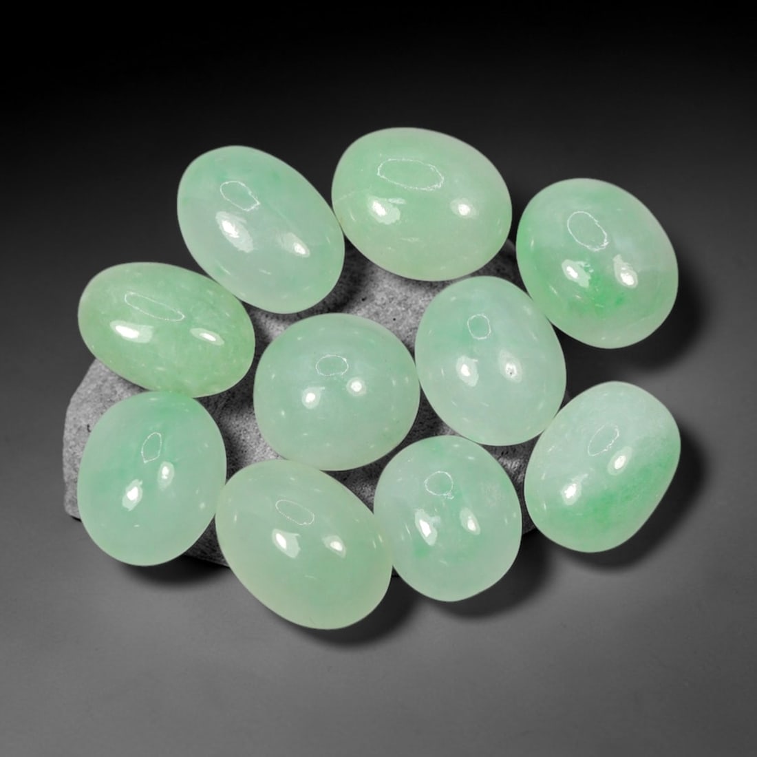 Natural Type A Jadeite Jade - Loose Cabochon Gemstone, 98AN: Crafted from natural Type A jadeite jade, these ten cabochons display a translucent pale green hue with subtle tonal variations inherent to the material. Each stone is cut en cabochon with a smooth, d