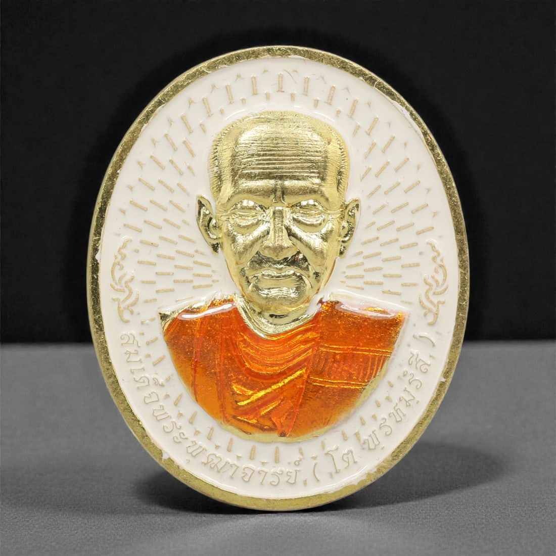 A Thai Gilt-Metal Monk Portrait Medallion, 21st Century, 84FP: Cast from metal with a gilt surface finish, the medallion is circular and double-sided with a raised gilt-metal border. The obverse features a high-relief gilt bust portrait of a Buddhist monk, set ag