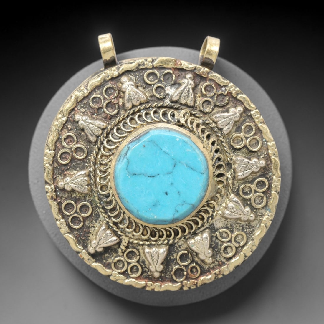 Vintage Himalayan Turquoise Brass Amulet Pendant, 20th Century, 5.5cm, 100ZQ: This vintage pendant is a fine example of 20th-century Himalayan tribal jewelry, crafted from brass with a central turquoise cabochon. The design employs repousse and filigree techniques, featuring a