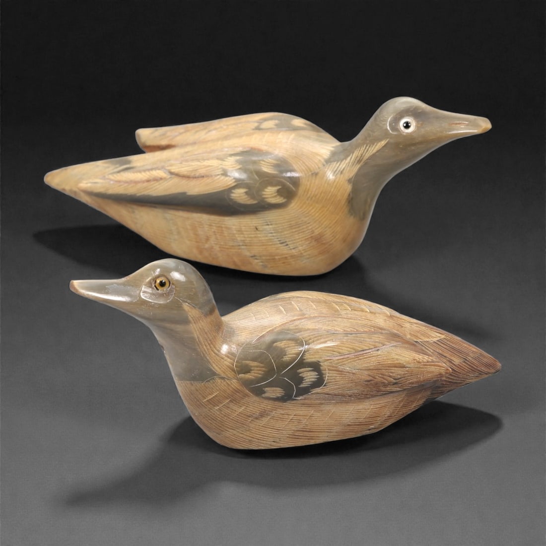 A Pair of East Asian Ox Horn Duck Effigies, 20th Century, 12FJ: Each carved from a single section of ox horn with natural tonal gradation from pale honey to darker brown, the two effigies are modeled as recumbent ducks rendered in the round. The heads are gently e