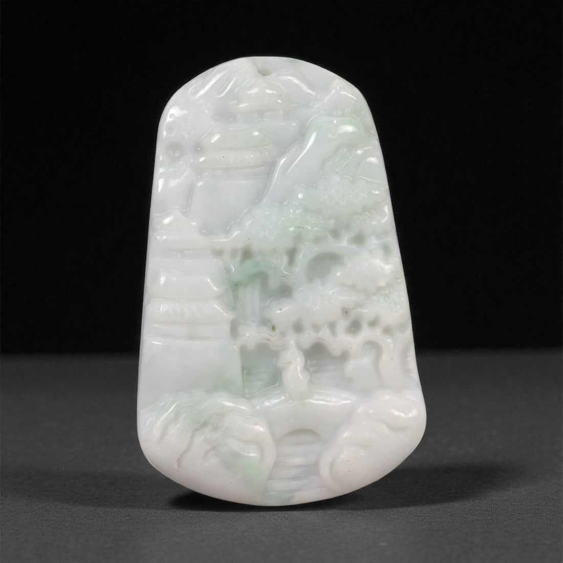 Chinese Jade Pendant Plaque - Carved Stone Relief, 75ZD: Carved from pale celadon jade with soft translucency and subtle greenish inclusions, this small pendant plaque is worked in shallow relief with stylized landscape and architectural motifs, the forms e