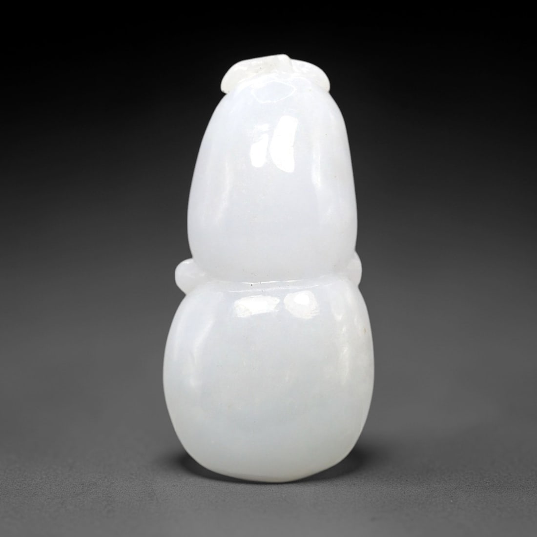 A Chinese Jadeite Jade Gourd-Form Pendant, 20th Century, 59FR: Carved from pale lavender-white jadeite jade with a uniform translucent matrix and minor natural internal veining, the pendant is modeled in the form of a double gourd, a motif known as hulu. The comp