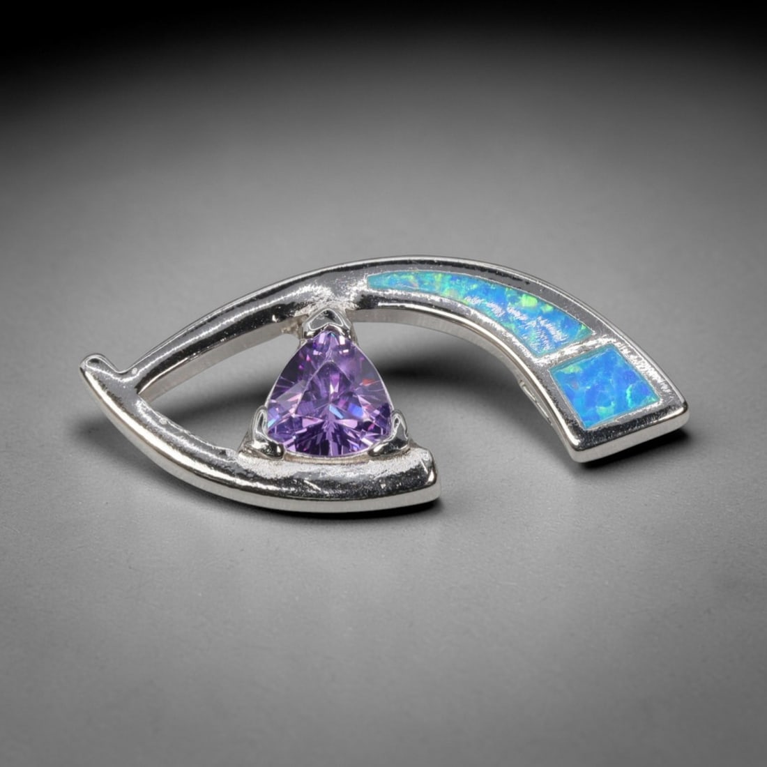 4.20g 925 Sterling Silver Eye Pendant - Simulated Opal Amethyst, 35D: Crafted from stamped 925 sterling silver, this pendant features a stylized eye-shaped openwork design. A trillion-cut deep purple amethyst-colored gemstone is secured by three prongs at the center, fo