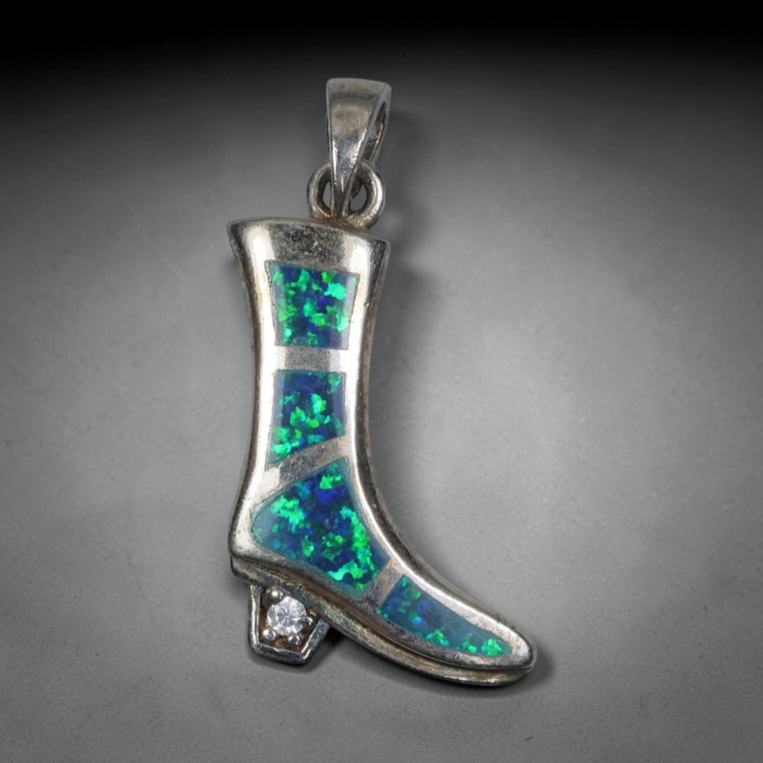 3.27g 925 Sterling Silver Boot Pendant - Simulated Opal, 38D: Crafted from stamped 925 sterling silver, this pendant is shaped as a stylized high-heeled boot with polished openwork detailing. The boot's shaft and toe are inlaid with four segments of simulated op