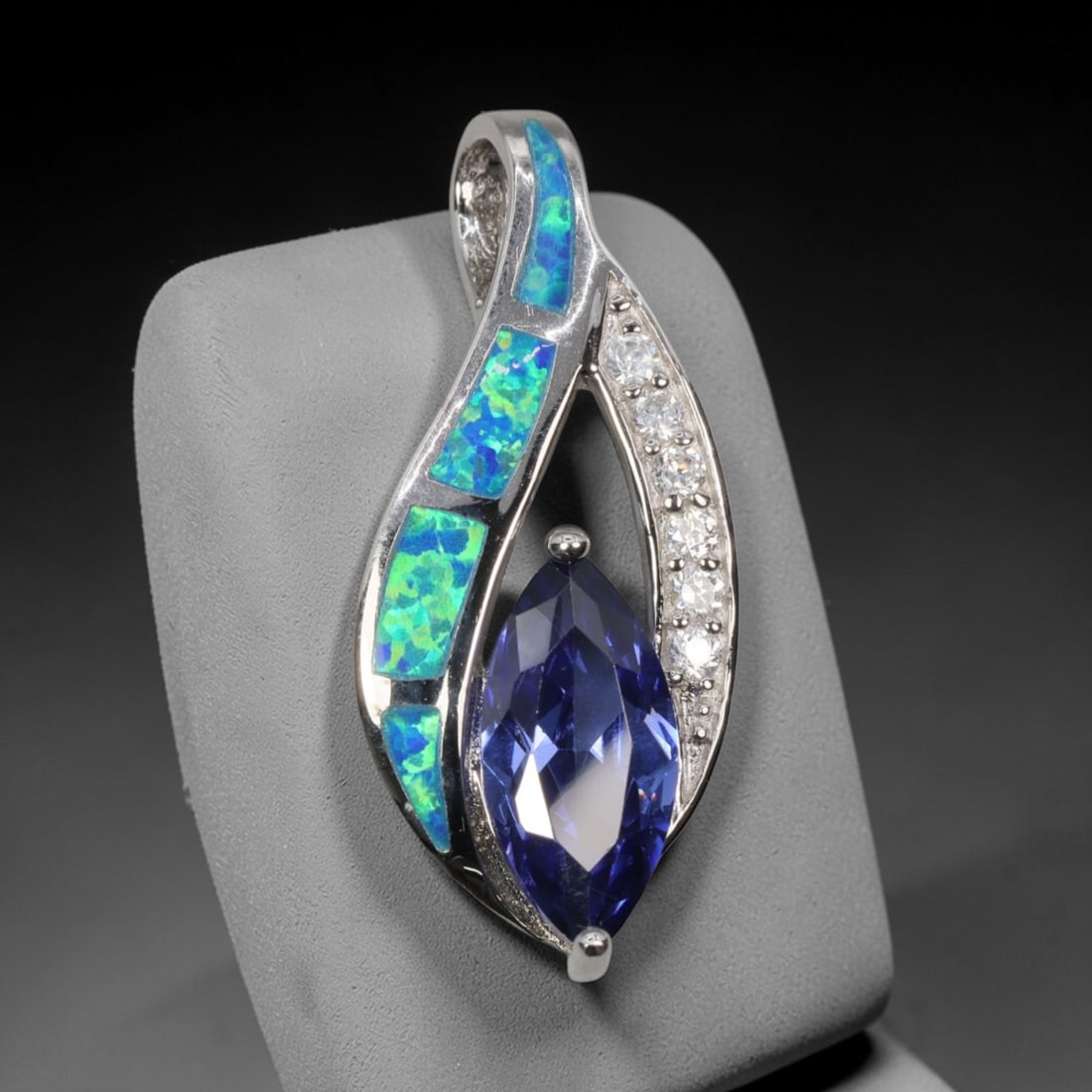 4.27g 925 Sterling Silver Leaf Pendant - Simulated Opal Iolite, 29D: Crafted from stamped 925 sterling silver, this pendant features an elegant leaf-shaped openwork design. Four rectangular segments of simulated opal are inlaid along one curved edge, exhibiting vivid i