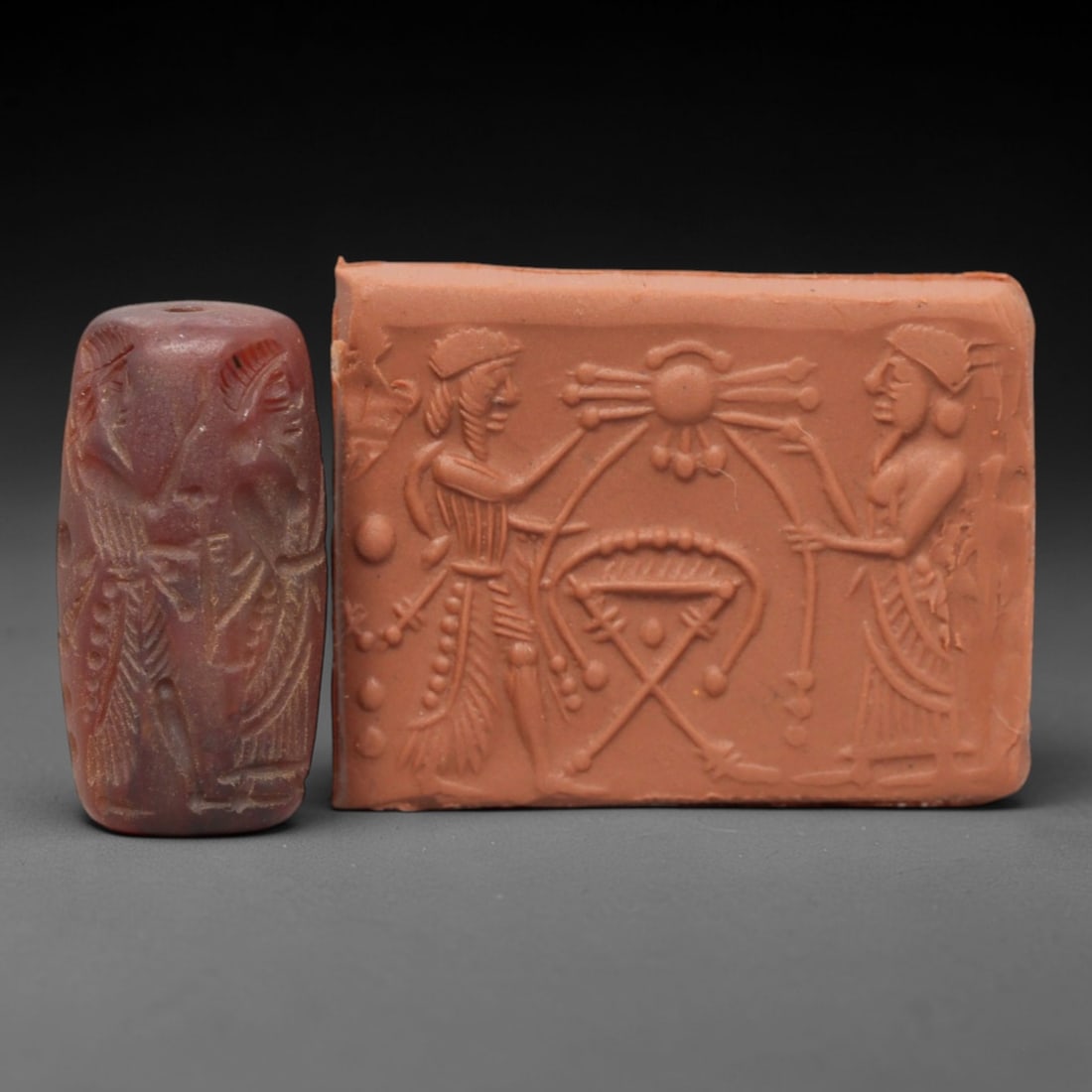 Ancient Carnelian Cylinder Seal - Mesopotamian Divine Ritual & Sacred Emblem Scene, 57AL: Carved from rich, deep-red carnelian, this ancient cylinder seal depicts a formal divine ritual scene, executed with meticulous glyptic craftsmanship characteristic of the Neo-Assyrian period. The cyl
