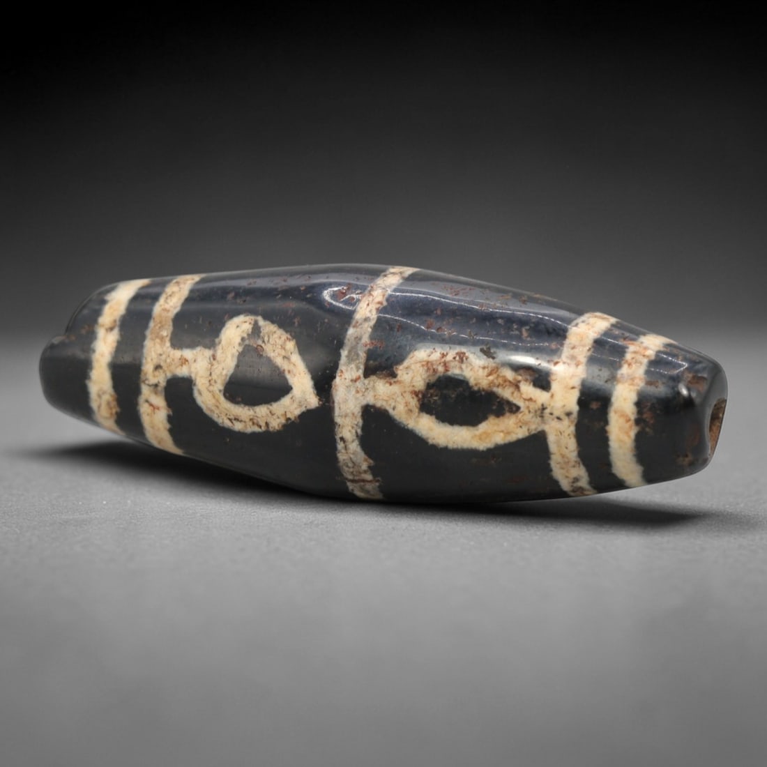 Ancient Agate Lotus / Heart Motif Dzi Bead - Himalayan Amulet, 81XV: Crafted from dark translucent agate, this bead features distinctive etched white lotus (or heart-shaped) floral motifs, flanked by parallel linear bands, executed in the traditional Himalayan Dzi bead