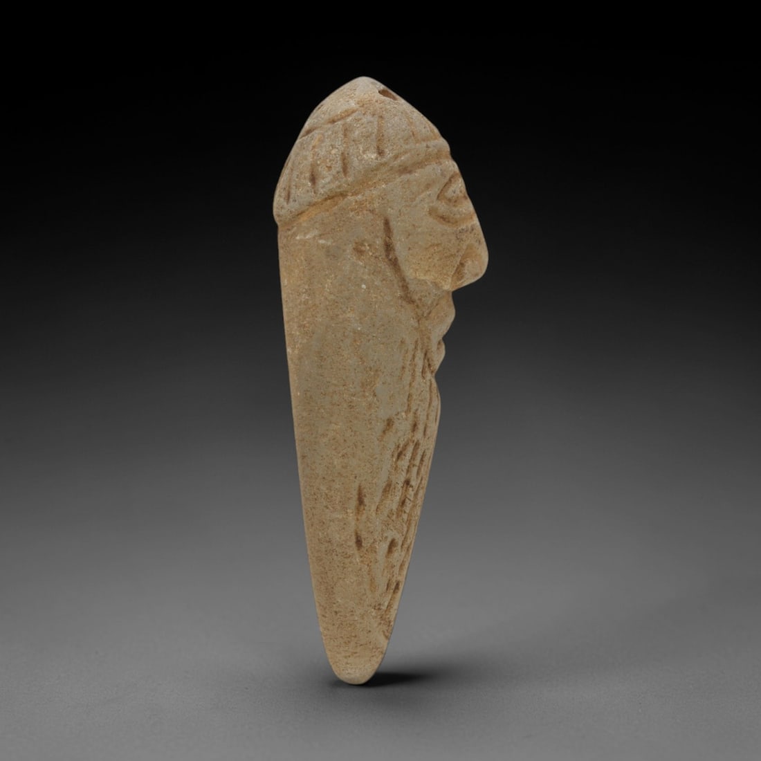 Ancient Rock Crystal Anthropomorphic Pendant - Near Eastern Carved Pendant, 74ZQ: Carved from rock crystal, this ancient Near Eastern pendant features a stylized anthropomorphic head with detailed facial features and incised detailing along the neck and shoulders. The crystal exhib