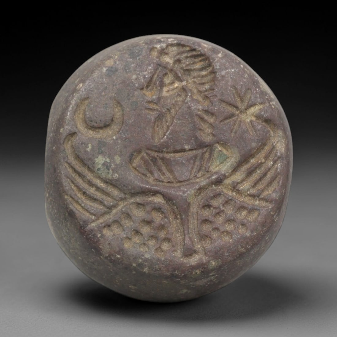 Ancient Stone Hemispherical Stamp Seal - Near Eastern Winged Deity, 46ZP: Crafted from a dense, reddish-brown stone, this hemispherical stamp seal bears a deeply incised depiction of a winged Near Eastern deity, adorned with a stylized headdress and beard, flanked by a cres