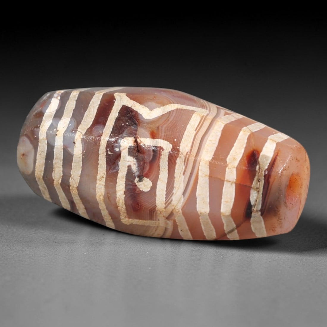 Ancient Agate Dzi Bead - Himalayan Etched Amulet, 97AR: This ancient elongated bead is crafted from polished banded agate, featuring a pale pinkish-brown base with crisp white etched linear and geometric motifs, including a central stylized eye motif flank