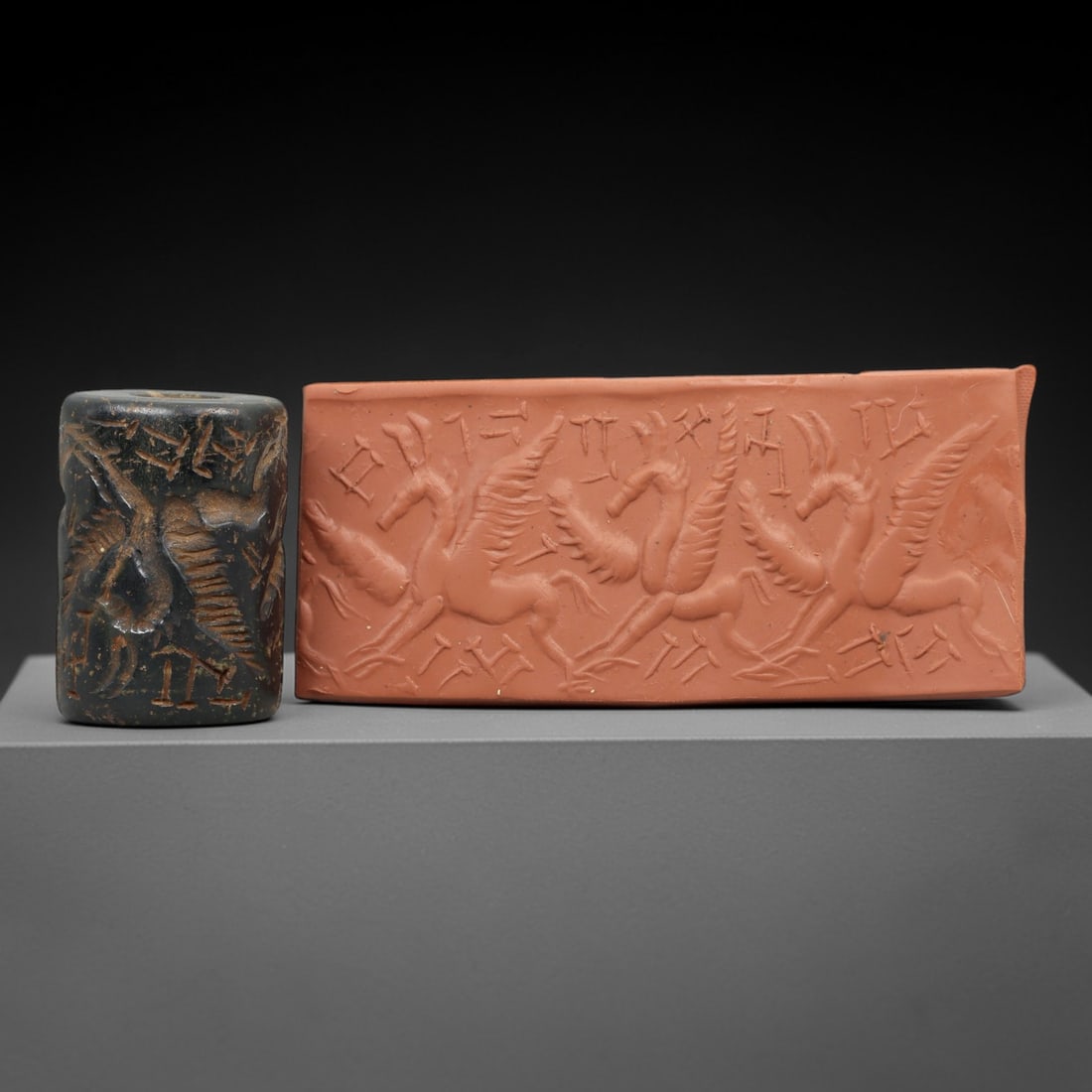 Ancient Steatite Cylinder Seal - Mesopotamian Winged Horses & Cuneiform Scene, 63AN: Carved from dense steatite, this ancient Mesopotamian cylinder seal features a dynamic linear relief composition of three winged horse figures in procession, interspersed with cuneiform inscriptions,