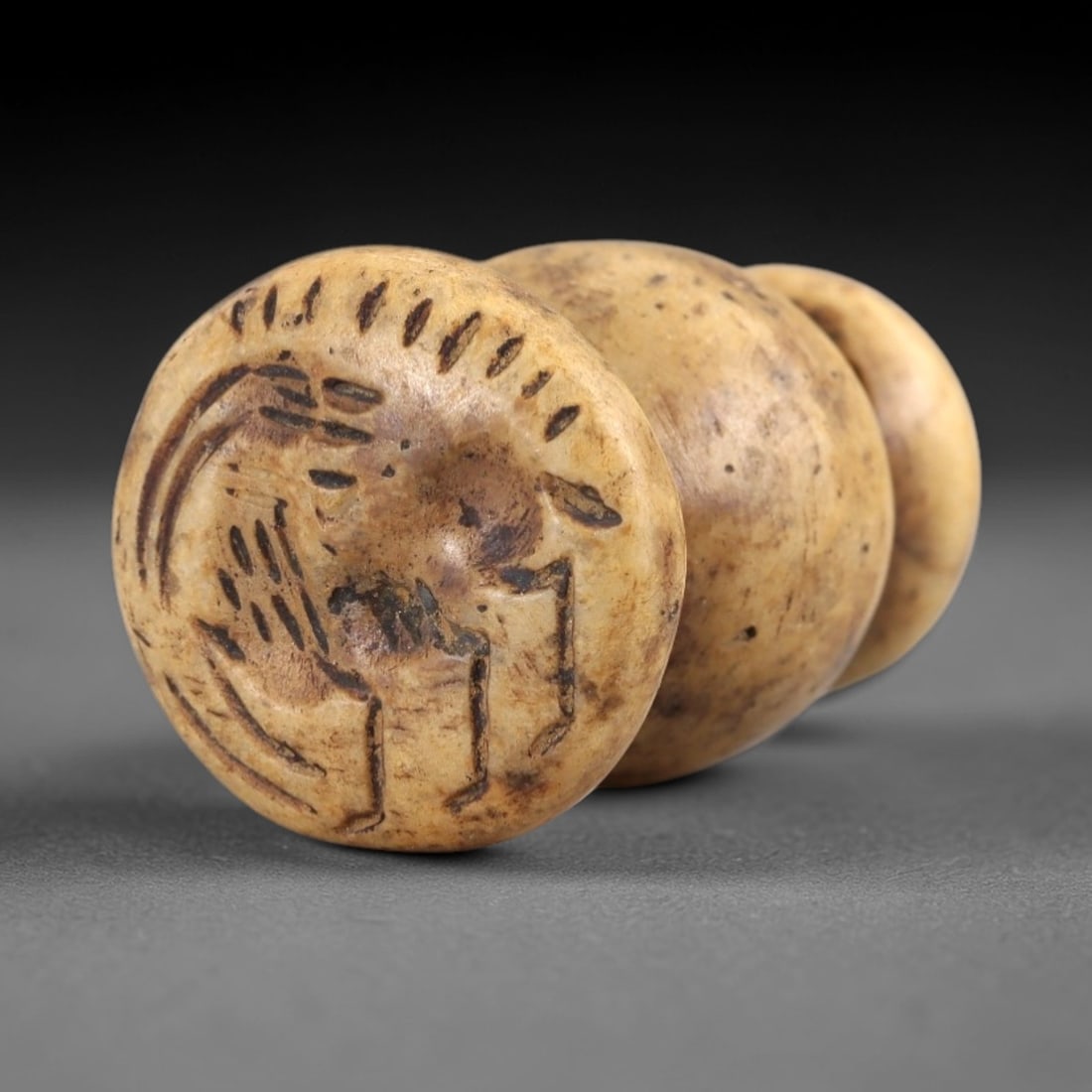 Ancient Stone Stamp Seal - Near Eastern Artifact, 70AL: This artifact is carved from stone, crafted as a stamp seal with a multi-tiered form and a flat, engraved base bearing incised decorative motifs including linear and circular patterns. The seal featur