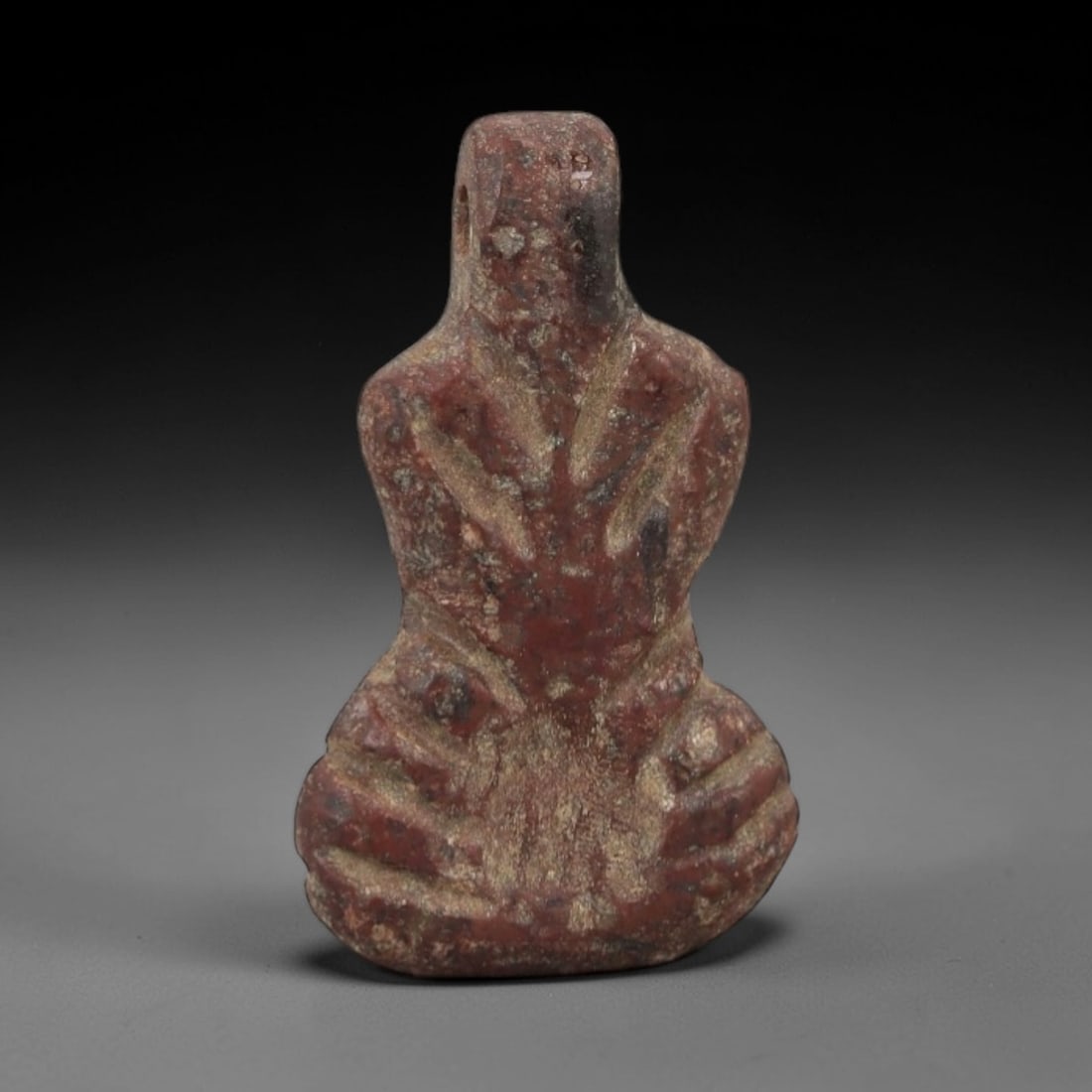 Ancient Egyptian Stone Amulet - Seated Figure Carving, 63AG: Carved from stone, this ancient Egyptian amulet depicts a stylized seated human figure, a motif associated with protection and divine guardianship in ancient Egyptian iconography. The compact carving