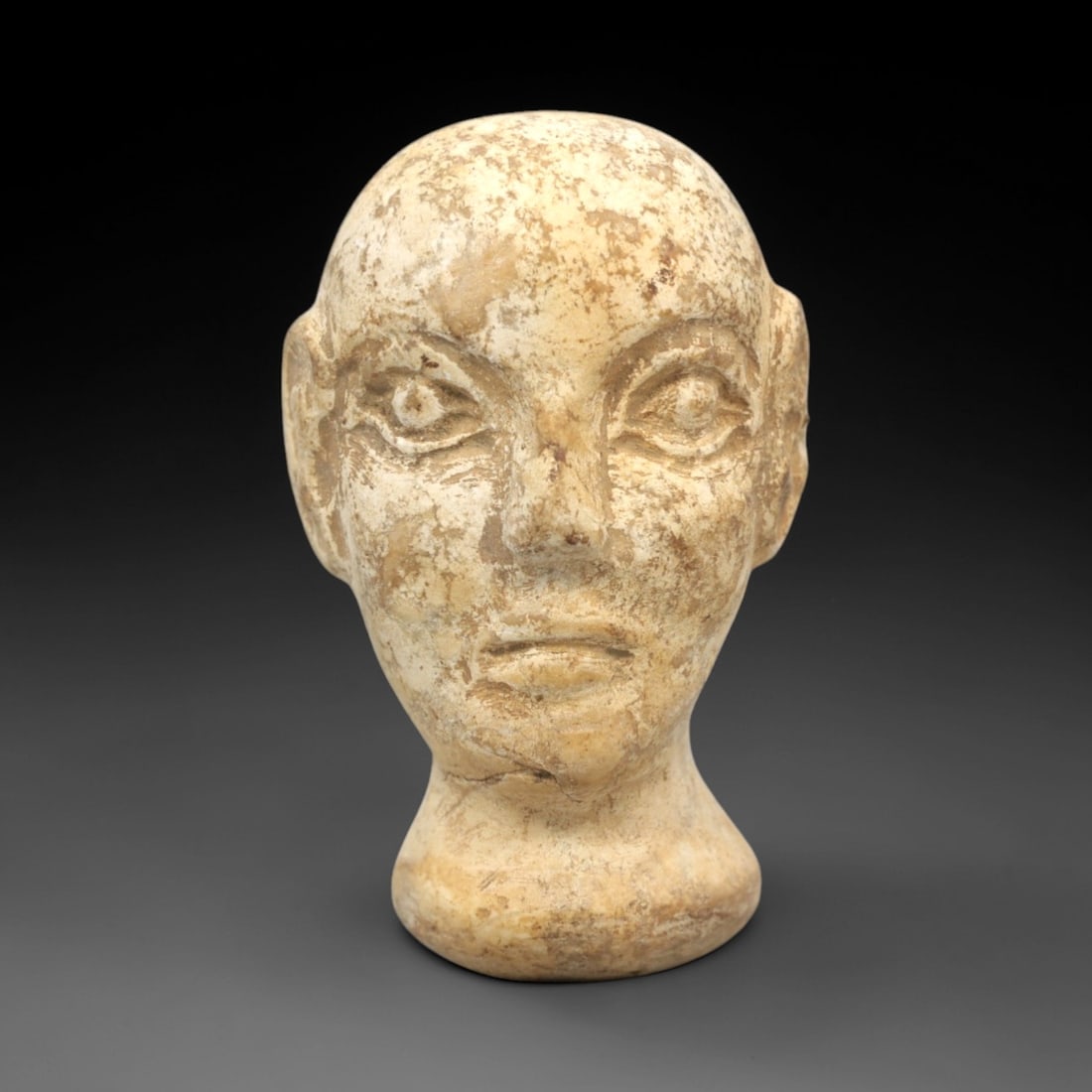 Ancient Stone Bactrian Idol Head - Central Asian Figurine, 46ZR: This artifact is a complete carved stone head of a Bactrian idol, executed in the stylized anthropomorphic tradition of ancient Central Asian Bactrian culture. The head features distinct facial featur