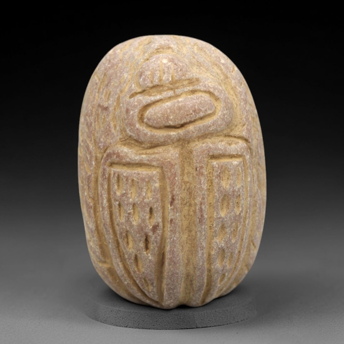 Ancient Egyptian Stone Scarab - Amulet Figurine, 53ZR: This artifact is a carved stone scarab amulet, crafted from a light reddish-brown stone with a granular texture and earthy patina filling the incised details. The dorsal surface displays stylized scar