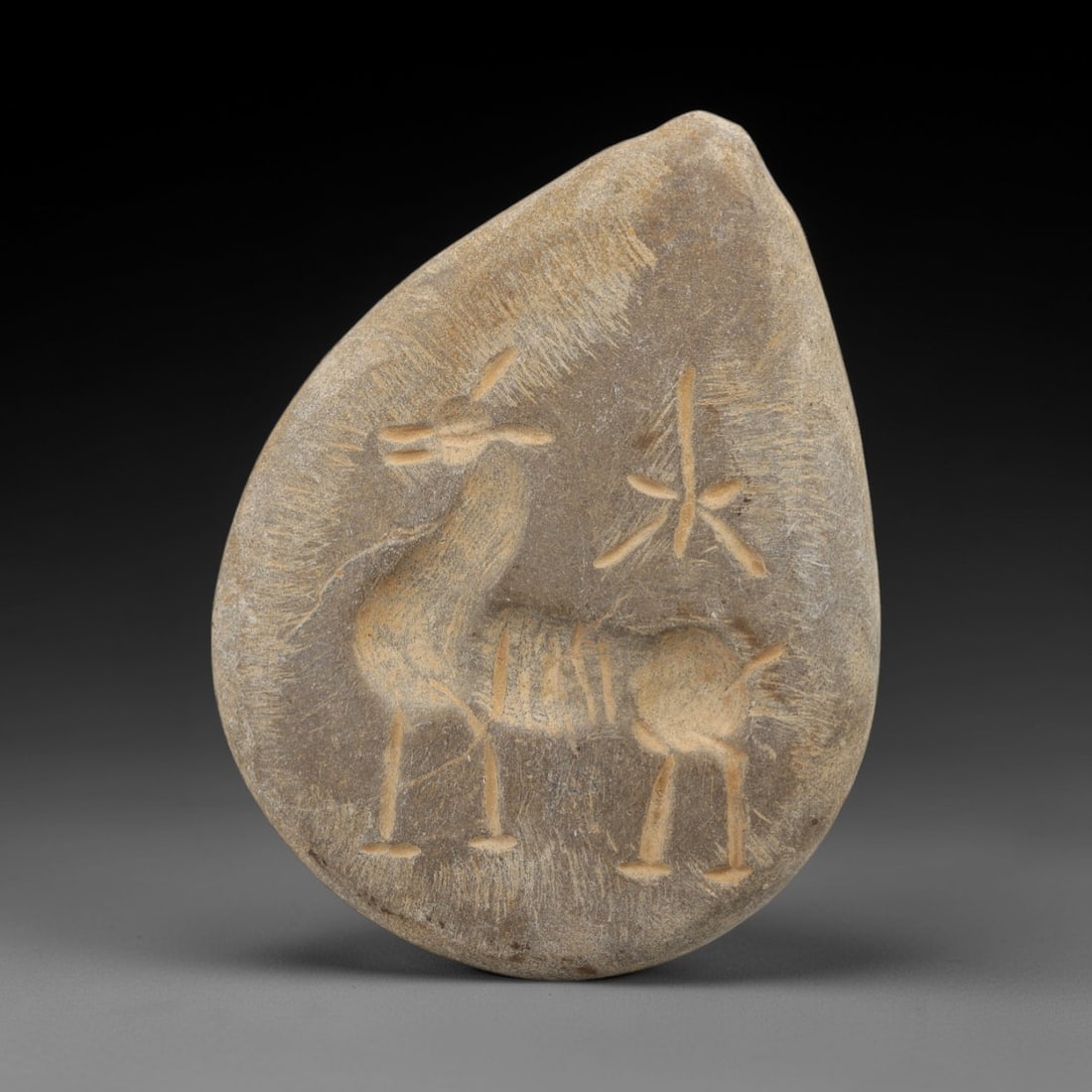 Ancient Steatite Amulet Pendant - Zoomorphic Carving, 86AG: Carved from steatite stone, this ancient amulet pendant features a stylized zoomorphic form with linear detailing, characteristic of Near Eastern glyptic art. The carving displays fine craftsmanship w