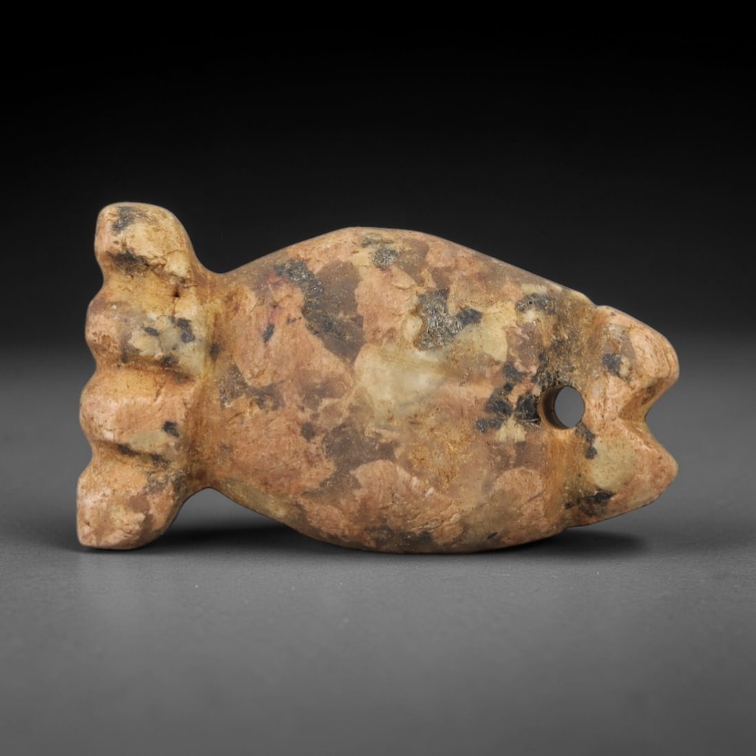 Ancient Stone Fish Amulet - Egyptian Style Figurine, 26AG: Carved from stone, this ancient Egyptian-style fish amulet features a compact, stylized piscine form with defined head, body, and tail details and a suspension hole at the top, indicating its use as a