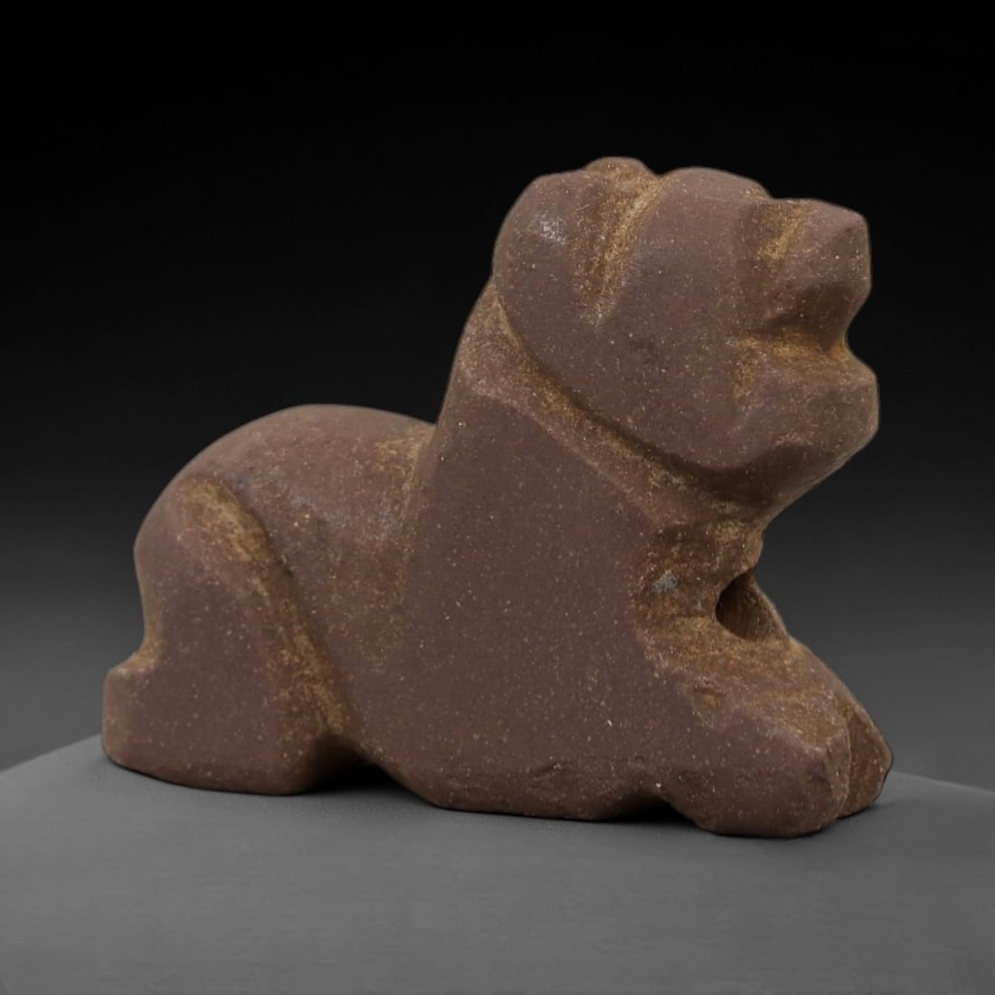 Ancient Brown Stone Recumbent Feline - Near Eastern Amulet, 97AD: Carved from compact brown stone with a fine-grained texture, this amulet depicts a recumbent feline in a stylized, robust form. The creature is rendered in a prone resting posture, with simplified fac