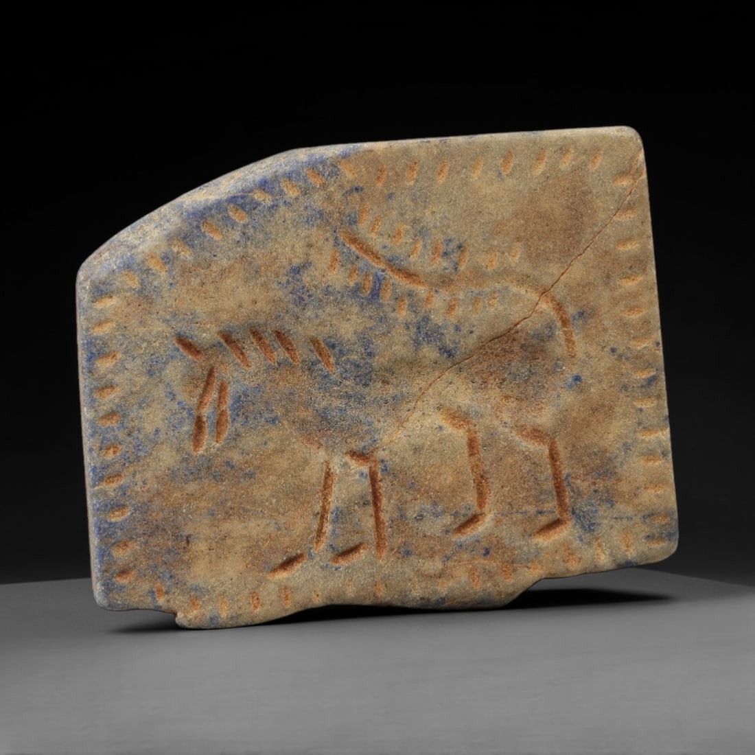 Ancient Lapis Lazuli Plaque - Near Eastern Animal Amulet, 6AJ: Carved from lapis lazuli stone, this ancient Near Eastern plaque features a stylized equine figure with detailed body markings and linear patterns. The carving exhibits fine glyptic craftsmanship typi