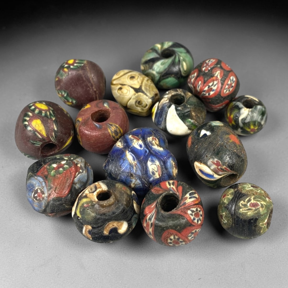 Antique Venetian Glass Beads - 14 Pieces, 14ZT: This set of 14 antique Venetian glass beads features hand-formed spherical and slightly irregular shapes, crafted from polychrome glass with intricate mosaic and cane-work patterns characteristic of t