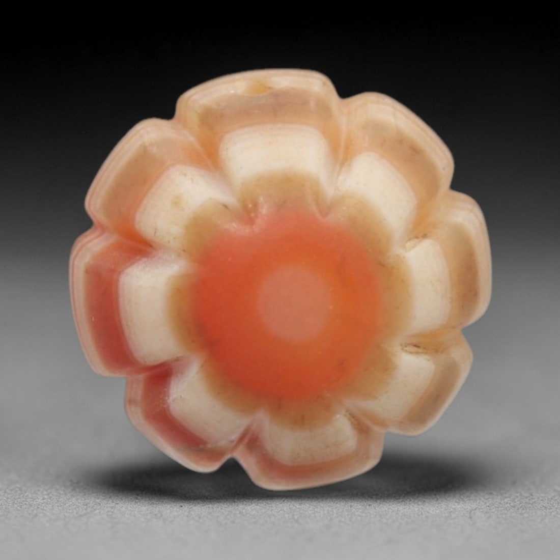 Antique Agate Eight-Petaled Flower Bead - Central Asian Carved Gemstone, 16ZW: Carved from banded agate with a warm reddish-orange central core and creamy white-peach concentric banding, this bead features a symmetrical eight-petaled floral form with raised, rounded petals radia