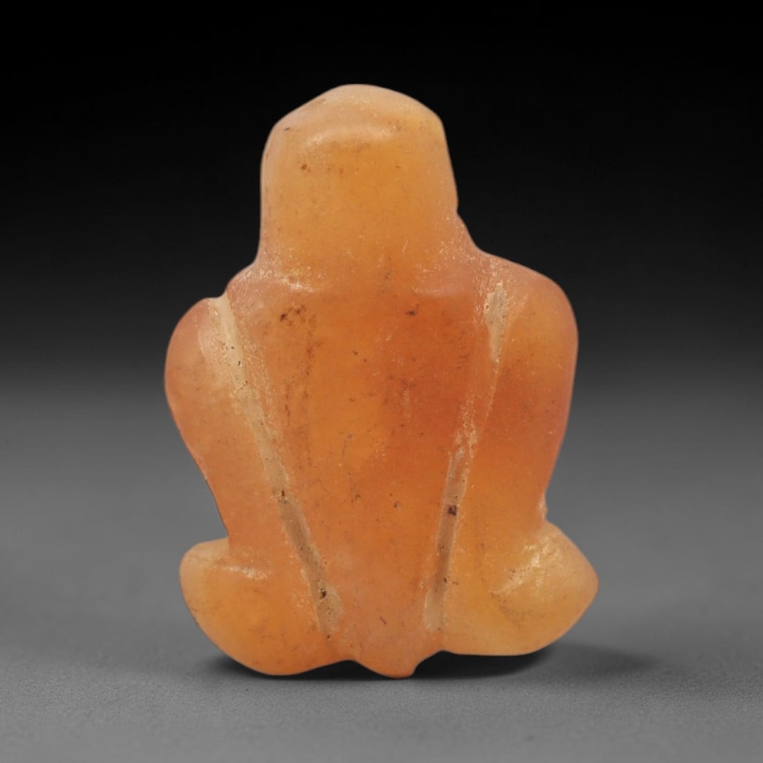 Ancient Carnelian Fly - Egyptian Amulet Figurine, 84XS: This amulet is carved from warm orange carnelian, exhibiting natural translucency and subtle banding characteristic of ancient Egyptian glyptic craftsmanship. The form is a stylized fly, with a compac