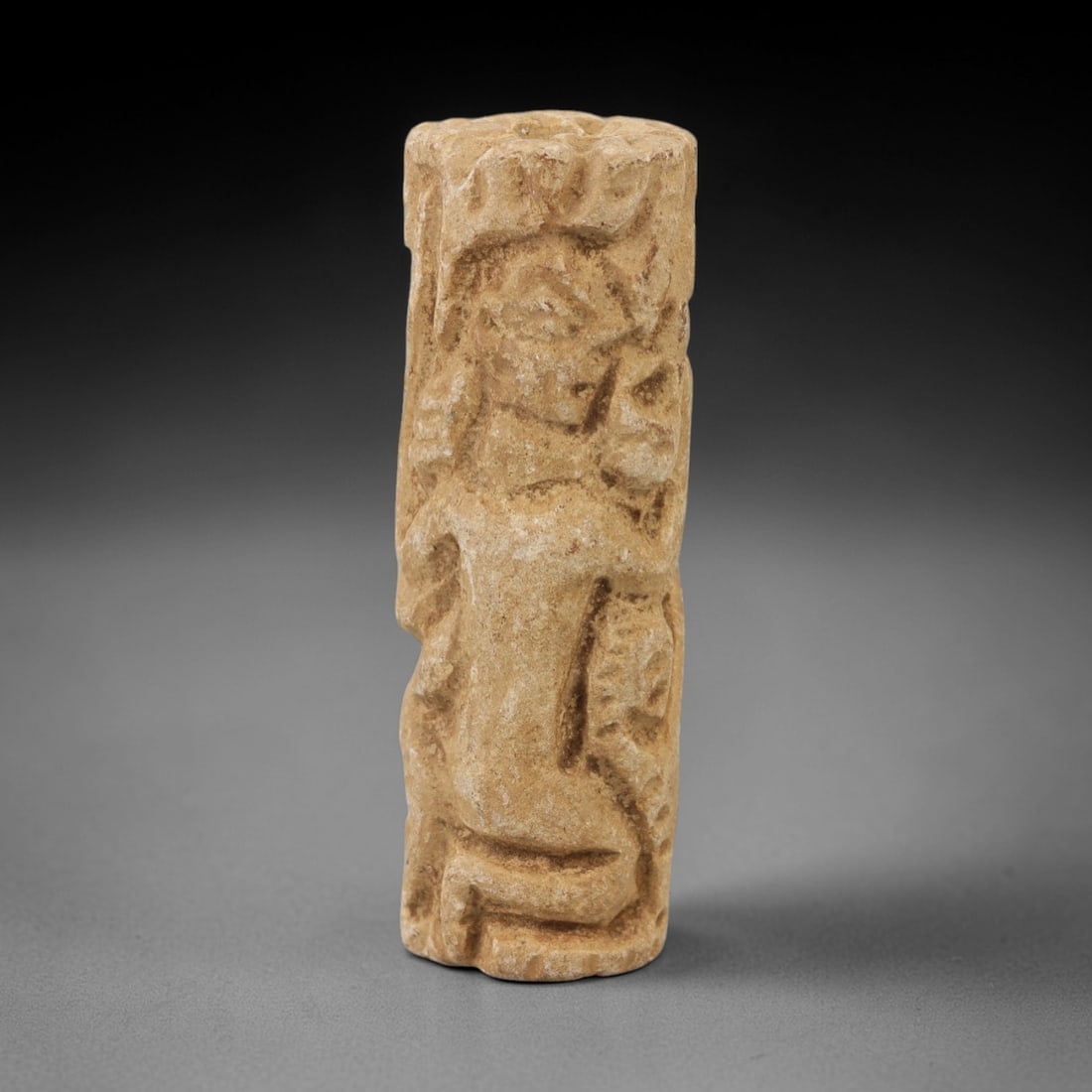 Ancient Limestone Cylinder Bead - Carved Relief Figurine, 44AH: Carved from limestone, this ancient cylinder bead features a slender, tubular form with raised relief detailing depicting a stylized humanoid figure, typical of ornamental use in early cultural contex