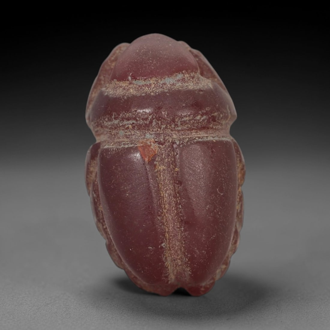 Ancient Red Jasper Scarab Amulet - Egyptian Figurine, 36AJ: Carved from deep, saturated red jasper, this amulet is formed as a stylized scarab beetle with incised linear detailing to define segmented body plates and distinct wing case patterns, consistent with