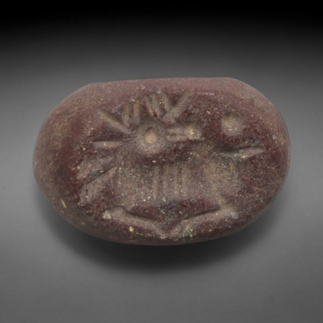 Ancient Stone Hemispherical Stamp Seal - Near Eastern Animal Figure, 3ZT: Crafted from dense, reddish-brown stone, this hemispherical stamp seal bears incised carving of a stylized animal figure, likely a mythical creature or bird, with distinct head crests, segmented torso