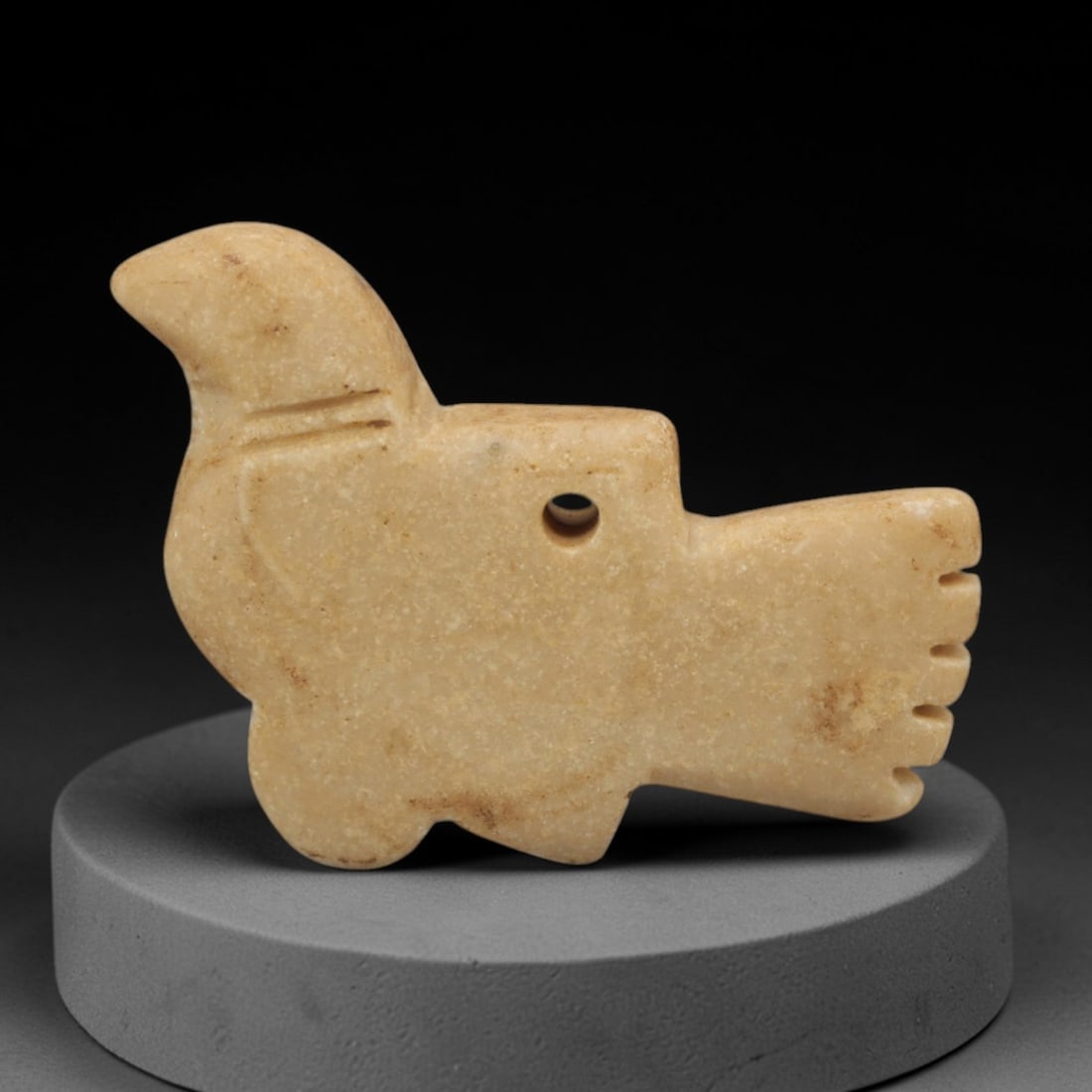 Ancient Stone Bird Amulet - Egyptian Animal Pendant, 16XR: This amulet is carved from a pale, creamy-white stone, shaped into a stylized bird form with a perforated suspension hole through the body, confirming its use as a wearable protective charm. The form