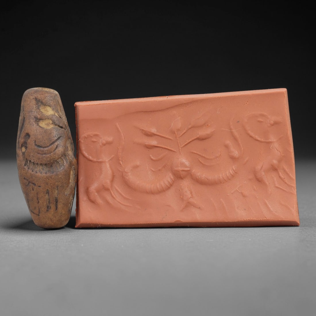Ancient Steatite Cylinder Seal - Mesopotamian Animal & Botanical Motif Scene, 59AN: Carved from dense steatite, this ancient Mesopotamian cylinder seal features a precise linear relief composition of leaping animal figures flanking a central symmetrical botanical motif, executed in t
