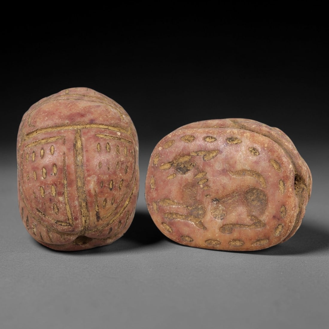 Ancient Egyptian Red Stone Scarab - Amulet Seal, 52AM: This artifact is a carved red stone scarab amulet seal, crafted from a granular, reddish-brown stone with a matte surface and earthy patina filling the incised decorative details. The dorsal side feat