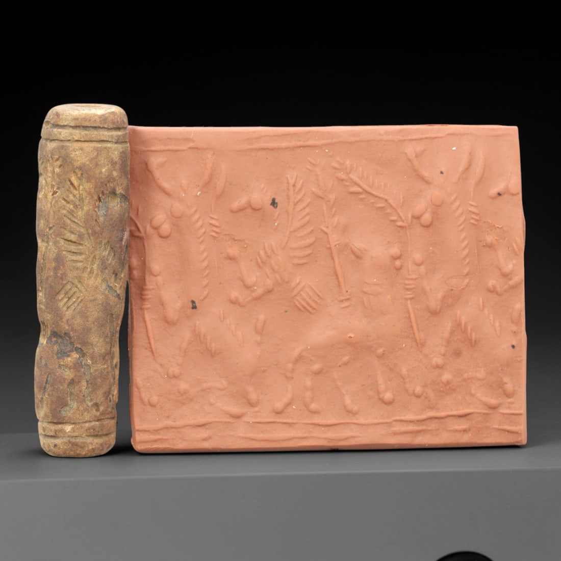 Ancient Steatite Cylinder Seal - Mesopotamian Animal Procession Scene, 88ZR: Carved from dense steatite, this ancient Mesopotamian cylinder seal features a linear relief procession of animal figures interspersed with botanical motifs, executed in the characteristic glyptic sty