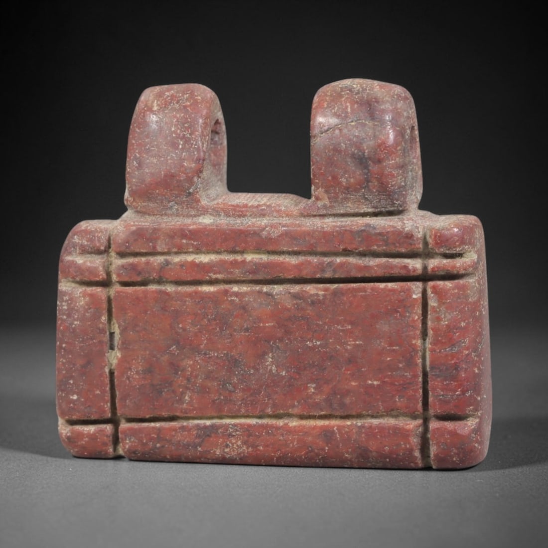 Ancient Stone Amulet - Egyptian Ritual Pendant, 41AP: This artifact is carved from variegated red stone with a weathered, earthy patina and natural mineral inclusions, exhibiting precise incised linear detailing consistent with ancient Egyptian stonework