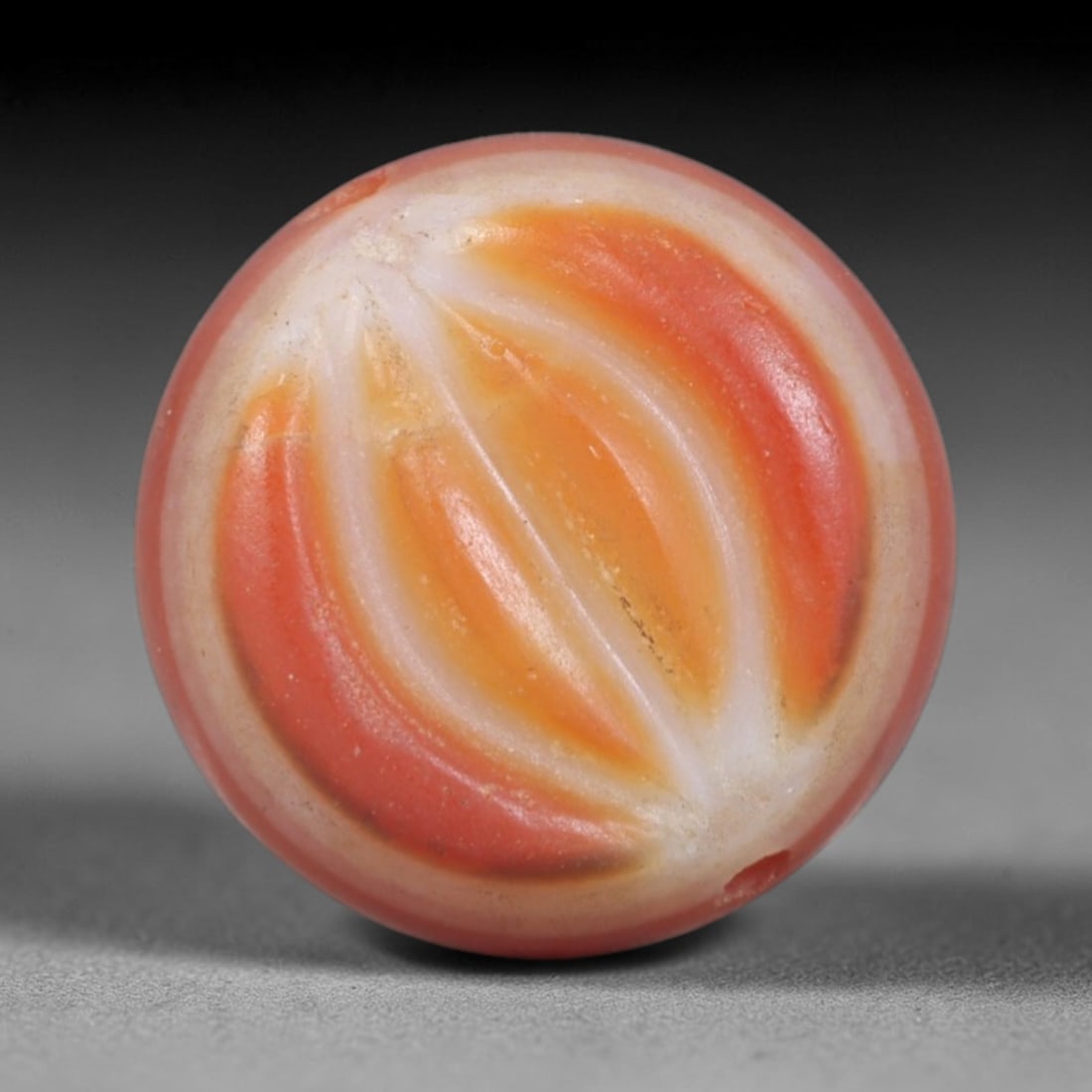 Antique Agate Melon Bead - Central Asian Gemstone Pendant, 3AR: Carved from banded agate with warm orange, white, and soft pink banding, this bead features a spherical form with deeply incised vertical fluting, creating a melon-like segmented appearance. A central