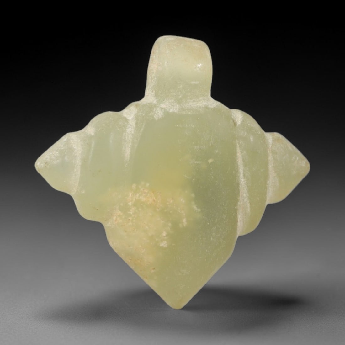 Ancient Serpentine Amulet - Egyptian Ritual Pendant, 46AR: Carved from pale green serpentine with subtle creamy mineral inclusions, this amulet features a symmetrical quatrefoil form with a raised suspension loop at the apex, characteristic of Egyptian protec