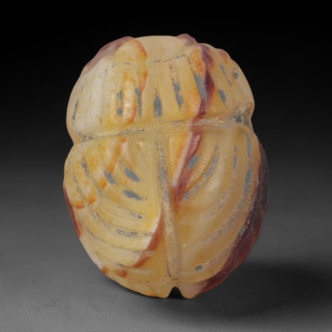 Ancient Banded Agate Scarab Amulet - Egyptian Figurine, 52XS: Carved from striking banded agate with warm golden-yellow, creamy white, and deep reddish-brown natural inclusions, this amulet is formed as a stylized scarab beetle with incised linear detailing to d